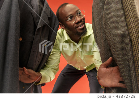 Handsome man with beard choosing shirt in a shop Handsome man with beard choosing shirt in a shop 43372728