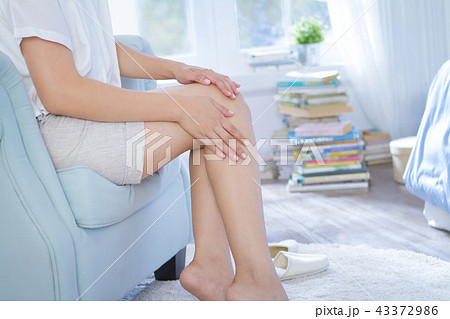 applying beauty lotion on her legs and knees 43372986