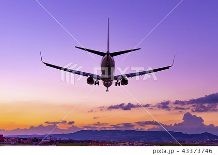 夕景の大阪伊丹空港に着陸する飛行機の写真素材