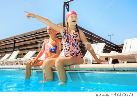 The portrait of happy smiling beautiful teen girls at the pool The portrait of happy smiling beautiful teen girls at the pool 43375573