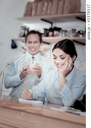 Relaxed waitress making notes and a waiter holding a glass 43376317