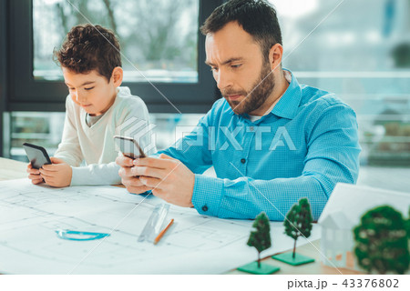 Attentive brunette male using his telephone Attentive brunette male using his telephone 43376802