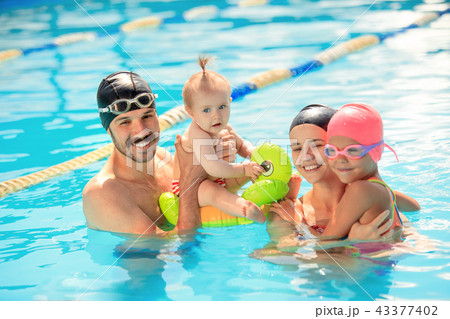 Happy family having fun by the swimming pool Happy family having fun by the swimming pool 43377402