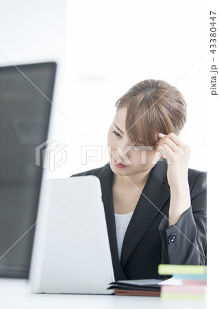会社で仕事をする若い女性 悩む 会社で仕事をする若い女性 悩む 43380447