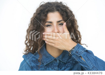 Surprised young woman covering mouth with hands Surprised young woman covering mouth with hands 43384470