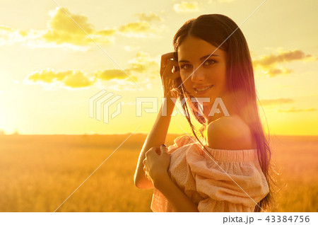 Woman in wheat field at sunset 43384756