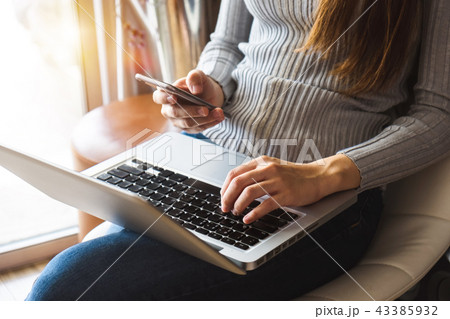 woman hand working with laptop and smart phone 43385932