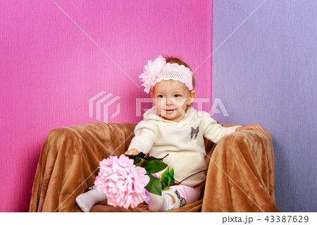 Little girl in the chair with flowers 43387629