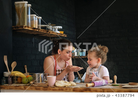 Mother and daughter prepare cookies in kitchen Mother and daughter prepare cookies in kitchen 43387794