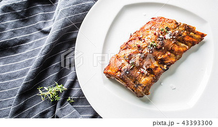 Grilled barbecue pork ribs in a white plate. 43393300