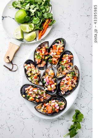PERUVIAN FOOD. Choros a la chalaca. Big mussels, choros zapatos seasoned with purple onion, tomatoes 43395985