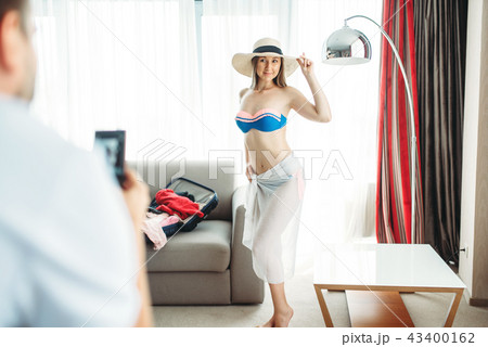 Young wife tries on swimsuit before vacation Young wife tries on swimsuit before vacation 43400162