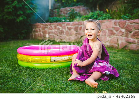 Summer vacation theme. A small 3 year old Caucasian boy playing in the backyard of a house on the Summer vacation theme. A small 3 year old Caucasian boy playing in the backyard of a house on the 43402368