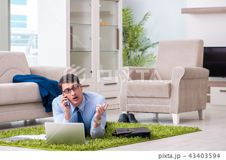 Businessman taking work home and working overtime Businessman taking work home and working overtime 43403594