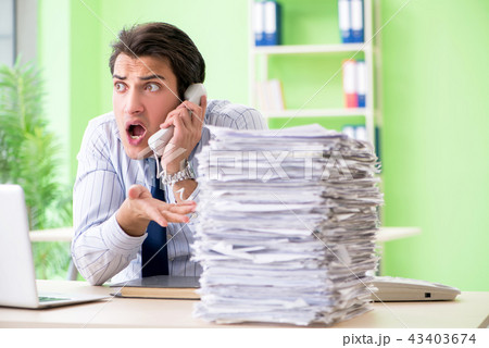 Businessman having problems with paperwork and workload Businessman having problems with paperwork and workload 43403674