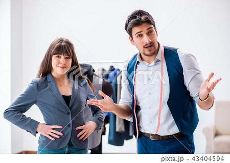 Professional tailor taking measurements for formal suit 43404594