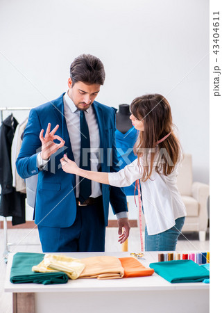 Professional tailor taking measurements for formal suit 43404611