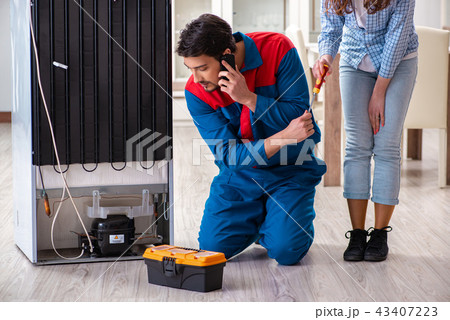Man repairing fridge with customer 43407223