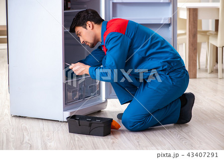 Man repairing fridge with customer 43407291