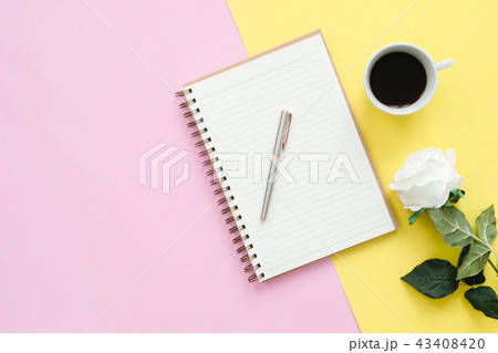 office desk with notebooks, flower, coffee cup. 43408420