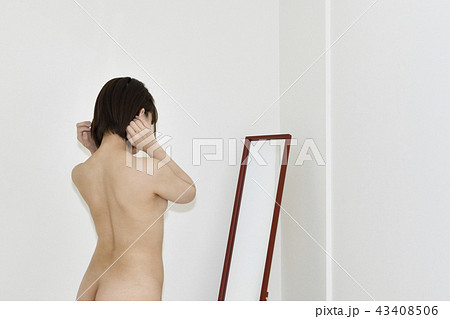 鏡に向かって髪を整える女性 43408506