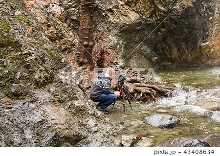 Young photographer with backpack making photos of waterfall and rocks with the camera. Mediterranean 43408634