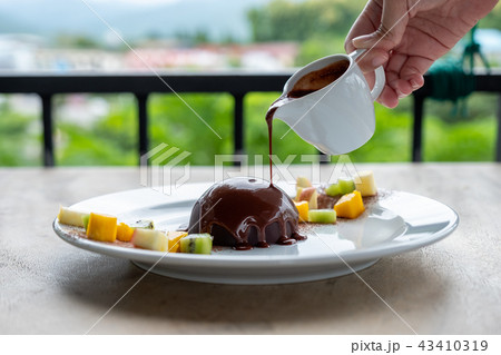 Hot chocolate pouring on cocoa dome dessert 43410319