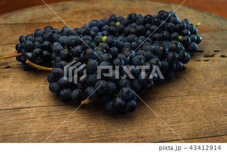 Grapes on a red wooden table and dark background. 43412914