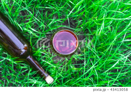 Glass of wine on a grass background, close up . 43413058