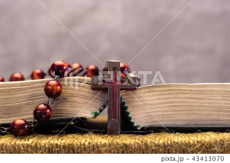 Bible and the crucifix beads on a golden table. Bible and the crucifix beads on a golden table. 43413070
