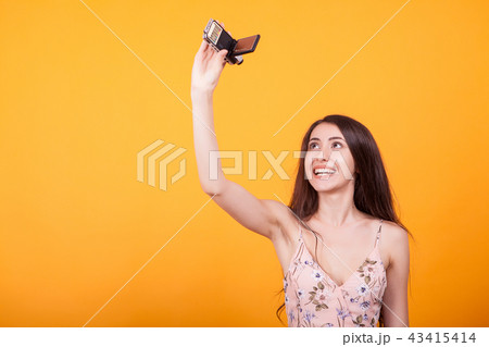Young beautiful woman playing with toy plane in studio over yellow background Young beautiful woman playing with toy plane in studio over yellow background 43415414
