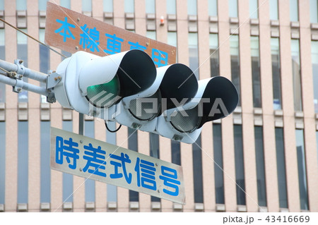 本線車専用」「時差式信号」の表示板のある信号機。の写真素材