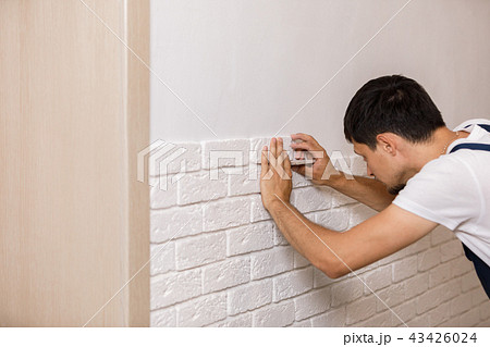 Professional Builder gluing decorative tile on wall. Professional Builder gluing decorative tile on wall. 43426024