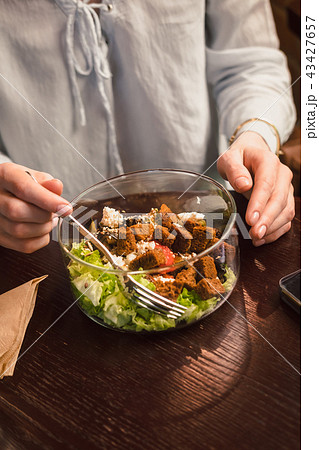 Woman's hands and bowl of green salad Woman's hands and bowl of green salad 43427657