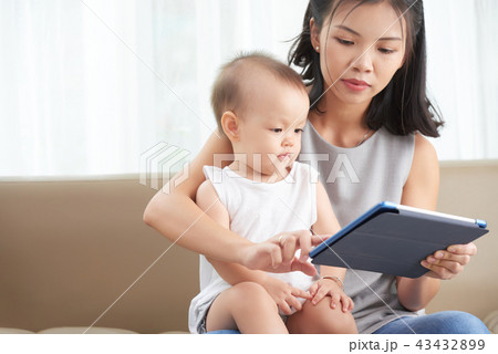 Mother showing tablet to daughter Mother showing tablet to daughter 43432899