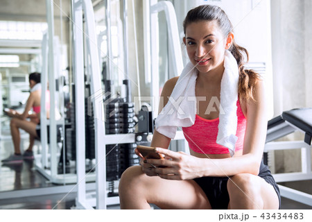 A woman resting from exercise and look at mobile phone 43434483
