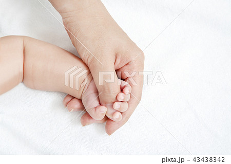 お母さんの大きな手の指を握る赤ちゃんの小さな手のアップ 母性 愛情 幸せ 育児 健康のイメージの写真素材