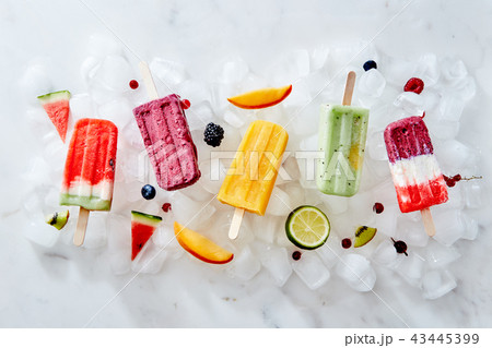 Different ice cream on a stick and different pieces of fruit and berries on ice cubes. Flat lay 43445399