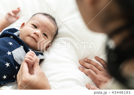 Asian mother's hand holding newborn baby fingers Asian mother's hand holding newborn baby fingers 43446193