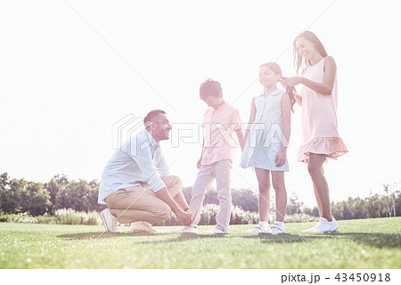 Family walk. Father helping son fixing the trousers while mother 43450918
