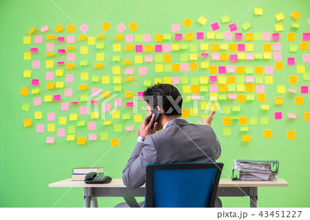 Businessman with many conflicting priorities    43451227