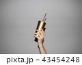 Hand Holding Golden Soda Cup  43454248