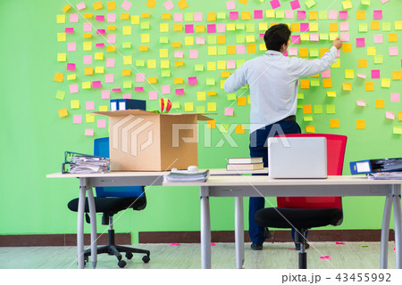 Man collecting his stuff after redundancy in the office with man 43455992