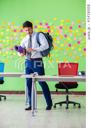 Man in the office with many conflicting priorities preparing go Man in the office with many conflicting priorities preparing go 43456008