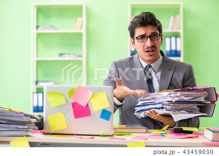 Businessman unhappy with many conflicting priorities sitting in  43459030