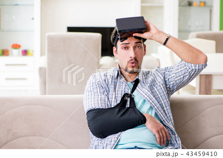 Young student man with hand injury wearing virtal glasses  43459410