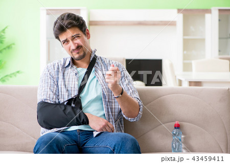 Young student man with hand injury sitting on the sofa  43459411
