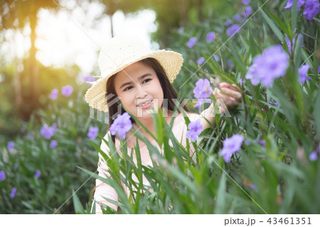 Beautiful asian girl looking at flower in garden 43461351