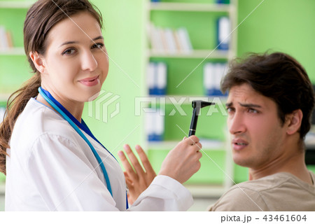 Female doctor checking patient's ear during medical examination Female doctor checking patient's ear during medical examination 43461604
