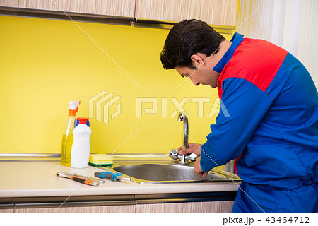 Plumber repairing tap at kitchen Plumber repairing tap at kitchen 43464712
